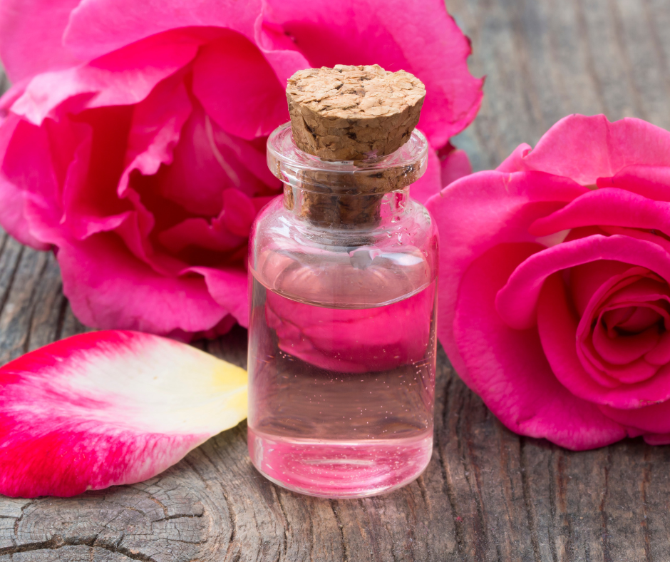 flacon d'eau de rose avec des roses autour